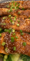 Oven-roasted miso glazed salmon fillet topped with sesame seeds, green onions, and cilantro, served with sautéed bok choy.