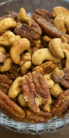 Bowl of festive mixed nuts with sweet and spicy seasoning, perfect for holiday snacking.