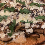 Cauliflower crust pizza topped with wild mushrooms, goat cheese, and fresh thyme.
