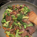 Homemade beef and broccoli stir fry in a skillet with glossy sauce.