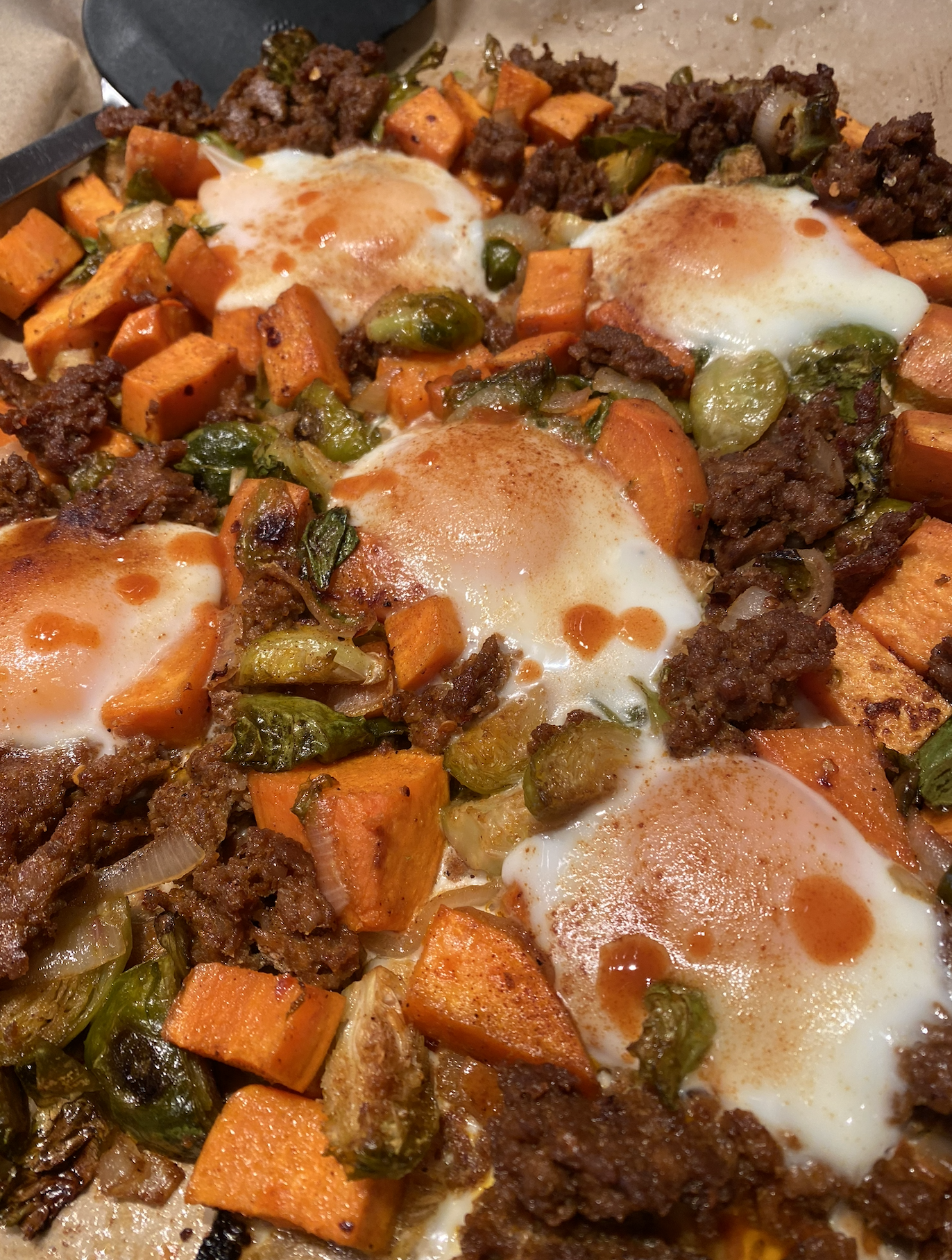 Sheet-pan breakfast with baked eggs, sweet potatoes, Brussels sprouts, shallots, and chorizo