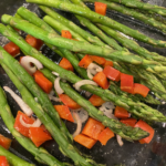 Warm asparagus salad with arugula, chopped eggs, and champagne vinaigrette on a serving platter