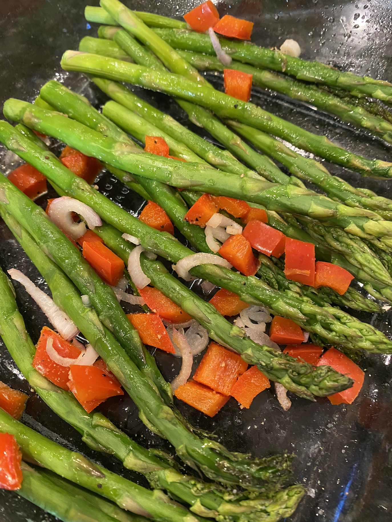 Warm asparagus salad with arugula, chopped eggs, and champagne vinaigrette on a serving platter